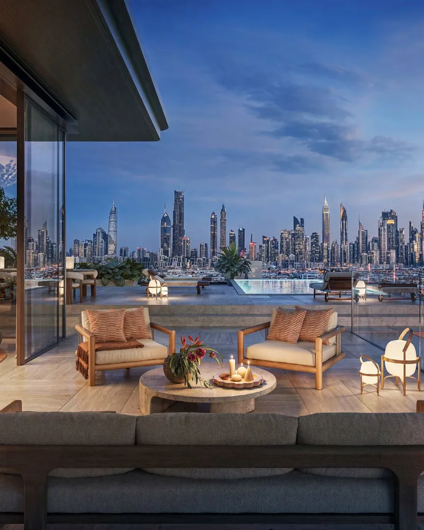 Penthouse terrace and private pool at dusk facing the lit city skyline